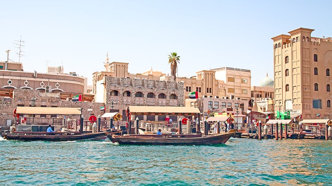 Dubai Creek with traditional abras and historic buildings on a sightseeing tour.