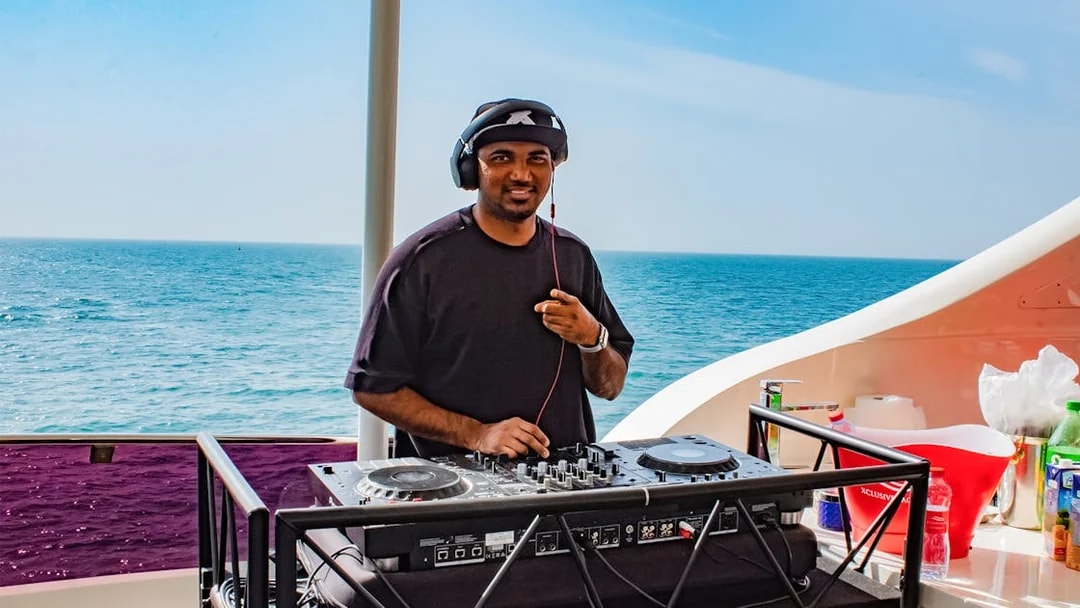 DJ performing on Superyacht TriDeck Cruise with ocean backdrop.