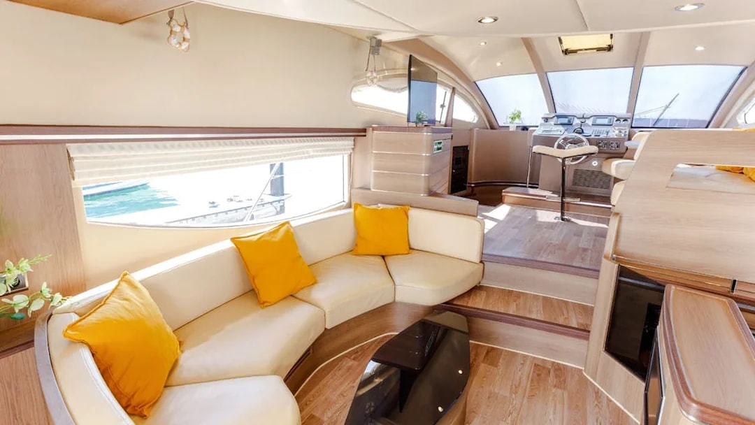 Interior seating area of VERONIKA Private Luxury Yacht with yellow cushions and helm view.