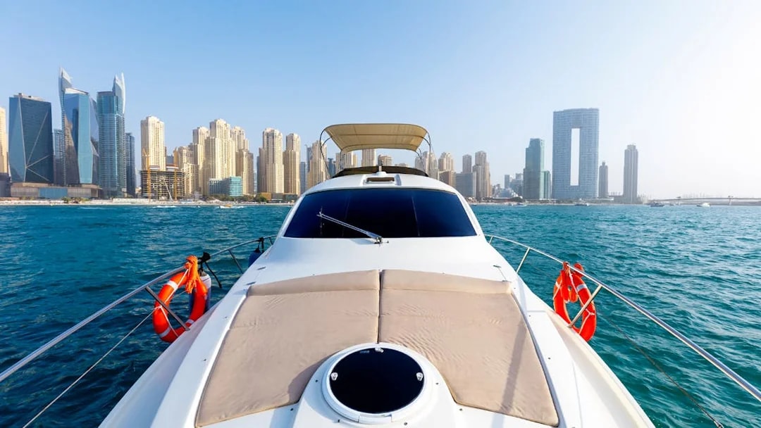Private yacht cruising with Dubai skyline in the background.