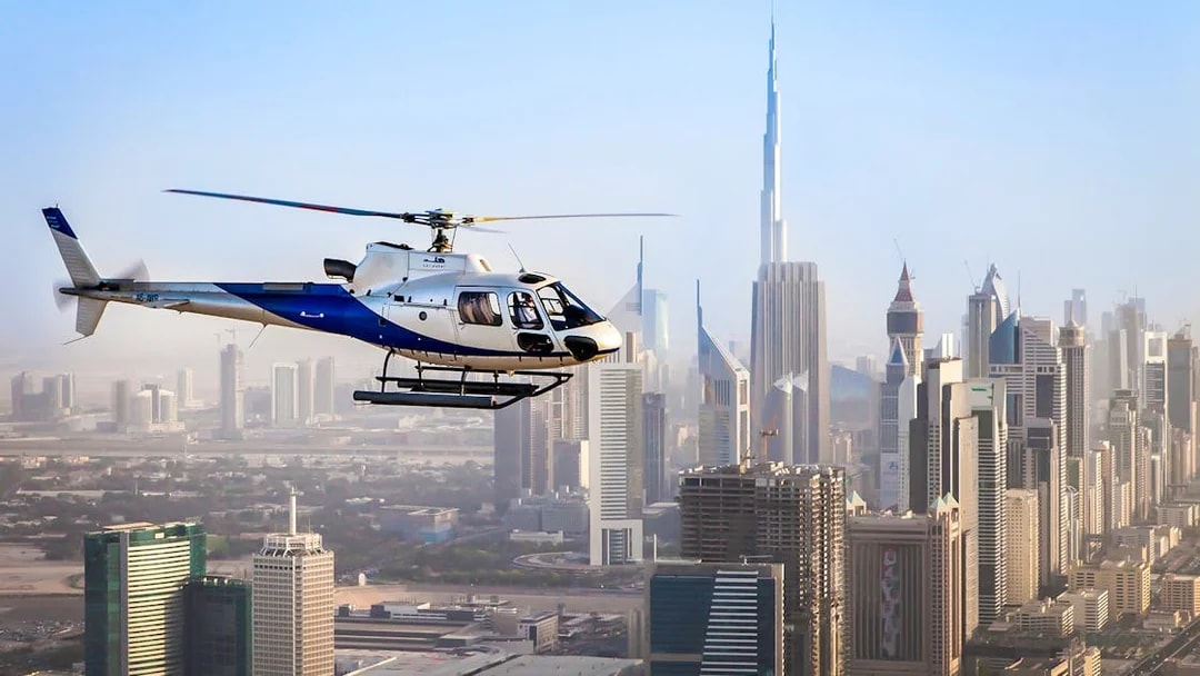 Helicopter flying over Dubai skyline with Burj Khalifa in view.