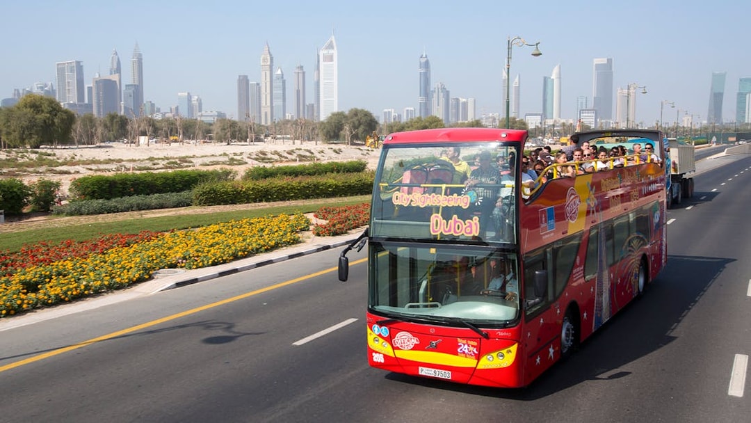 Open-top sightseeing bus in Dubai with city skyline in the background.