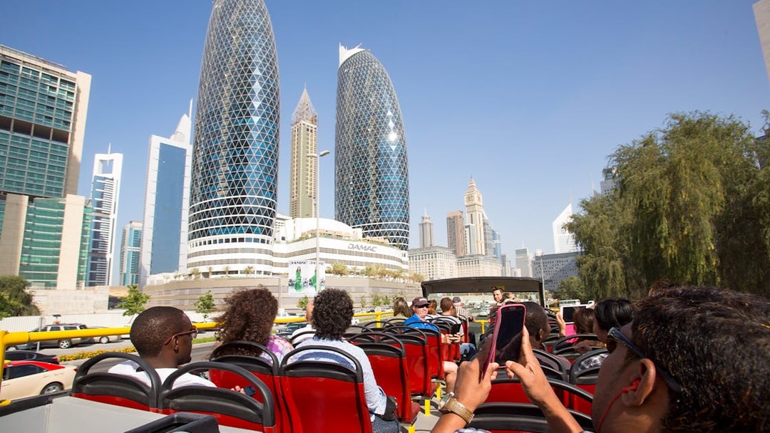 Open-top bus tour passing DAMAC Park Towers in Dubai.