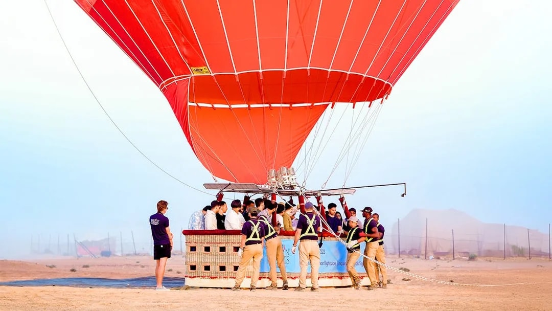 Hot air balloon preparing for launch in Dubai desert.