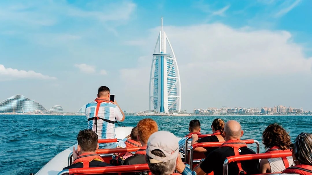 Speedboat tour group viewing Burj Al Arab from Dubai Marina.