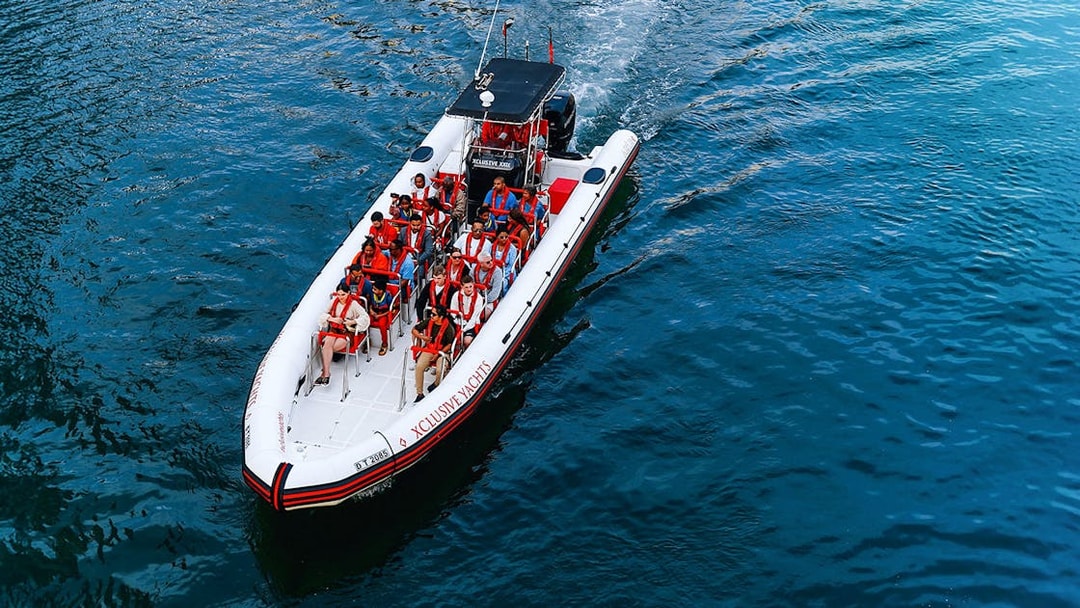 Speedboat with tourists on Dubai Marina tour, heading towards Atlantis and Burj Al Arab.
