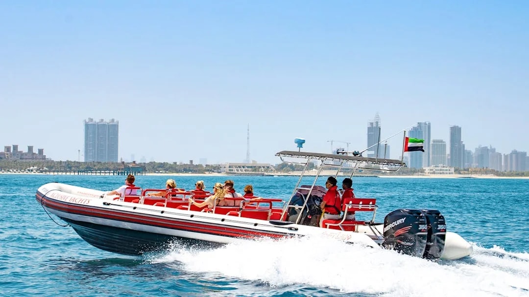 Speedboat with tourists on Dubai Marina tour, city skyline in background.