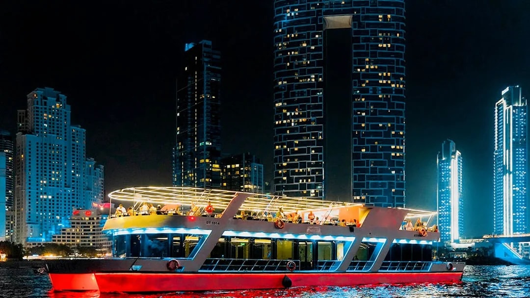 Sunset cruise boat with buffet dinner in Dubai Marina at night.