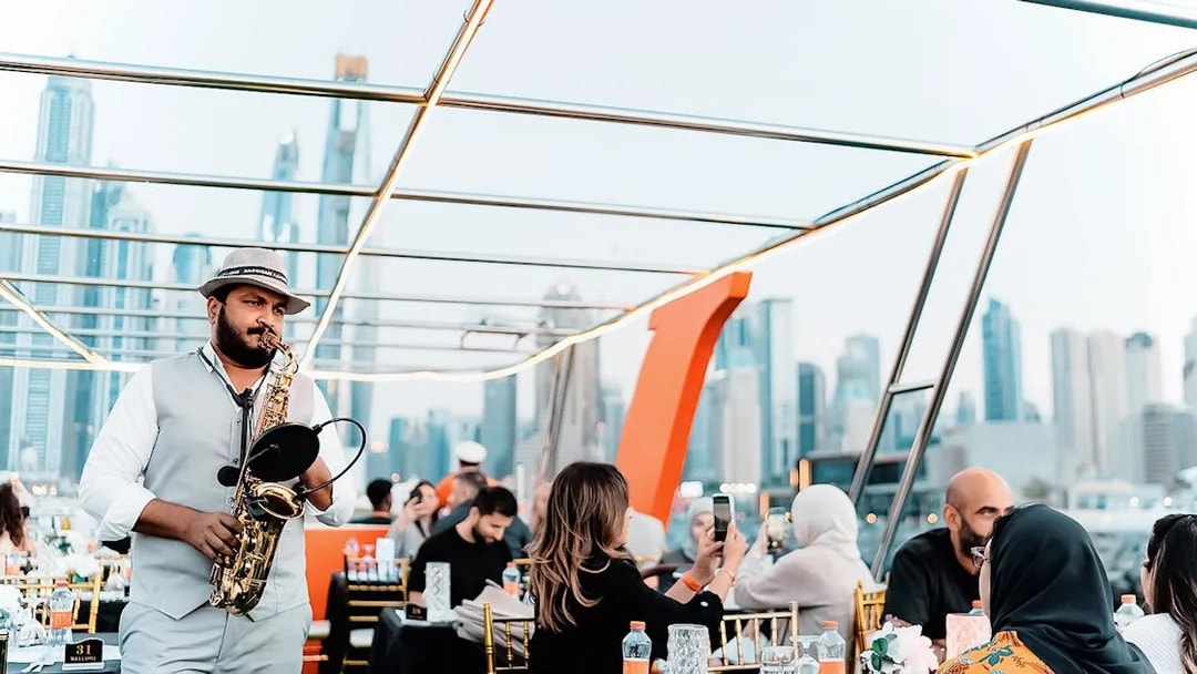 Saxophonist performing on a Dubai Marina sunset cruise with buffet dinner.