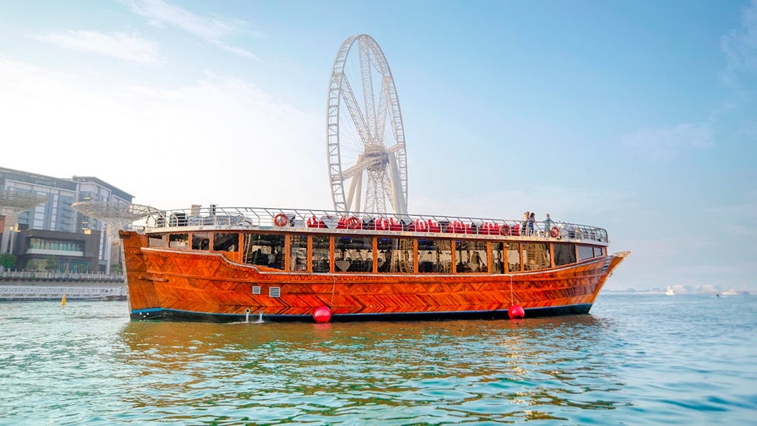 Dhow cruise on Dubai Creek with Ain Dubai in the background.