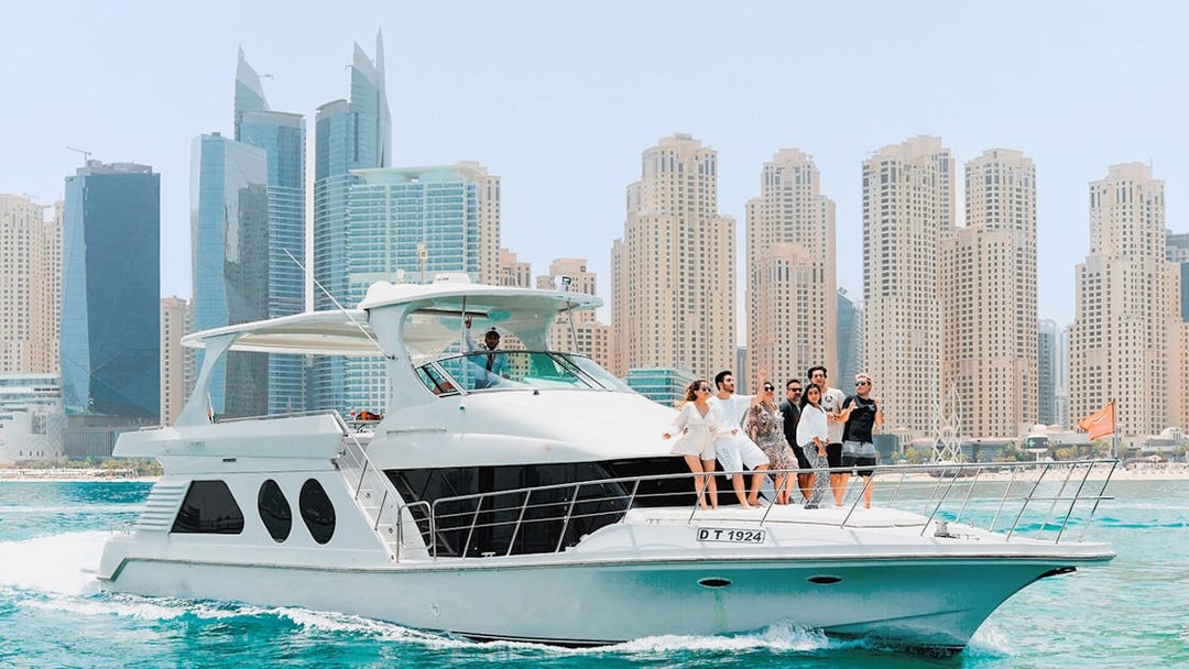 Bluewater yacht cruising with Dubai Marina skyline in the background.
