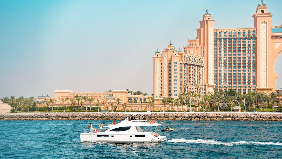 Luxury yacht cruising past Atlantis The Palm, Dubai.