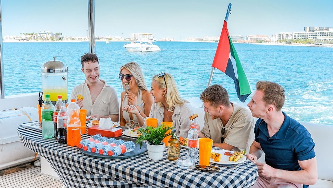 Guests enjoying breakfast on a luxury yacht cruise with ocean view.