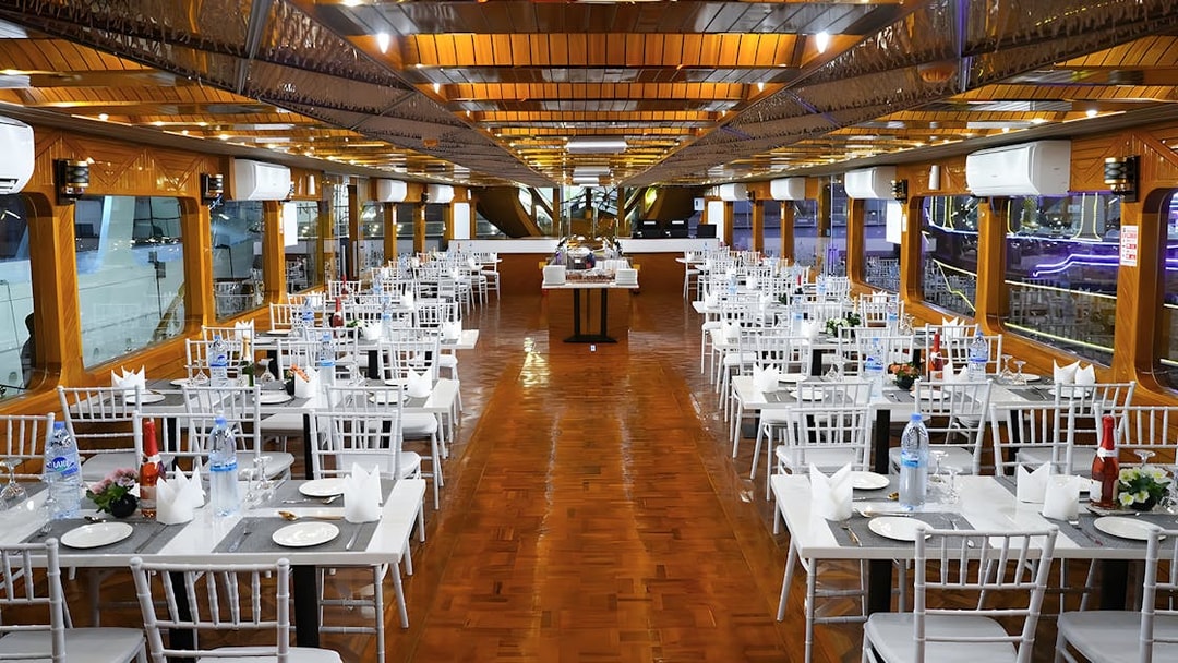 Dining setup on a dhow cruise in Dubai Marina with tables and chairs arranged for dinner.