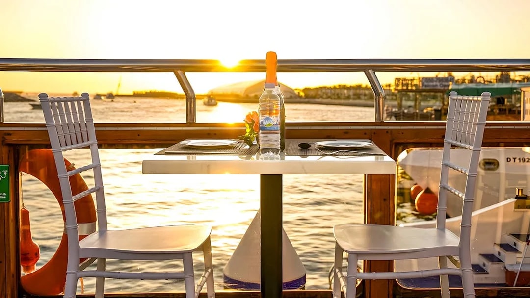 Dinner table on a dhow cruise at sunset, Dubai Marina.
