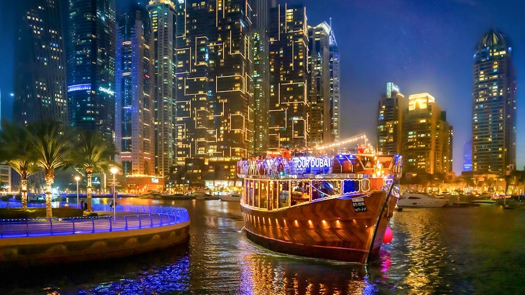 Luxury dhow cruise on Dubai Marina promenade at night with city skyline.