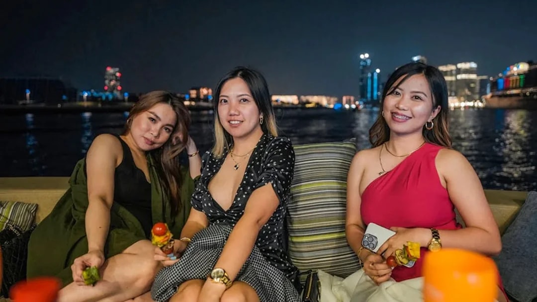 Ladies enjoying BBQ on a Dubai Marina yacht party at night.