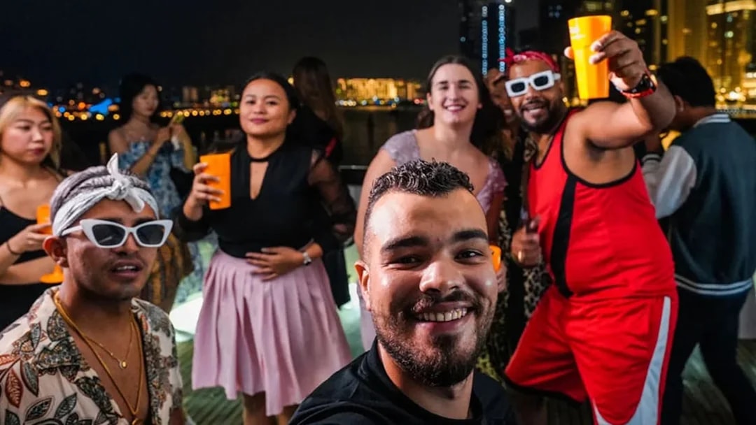 Friends enjoying a night party on a yacht at Dubai Marina.
