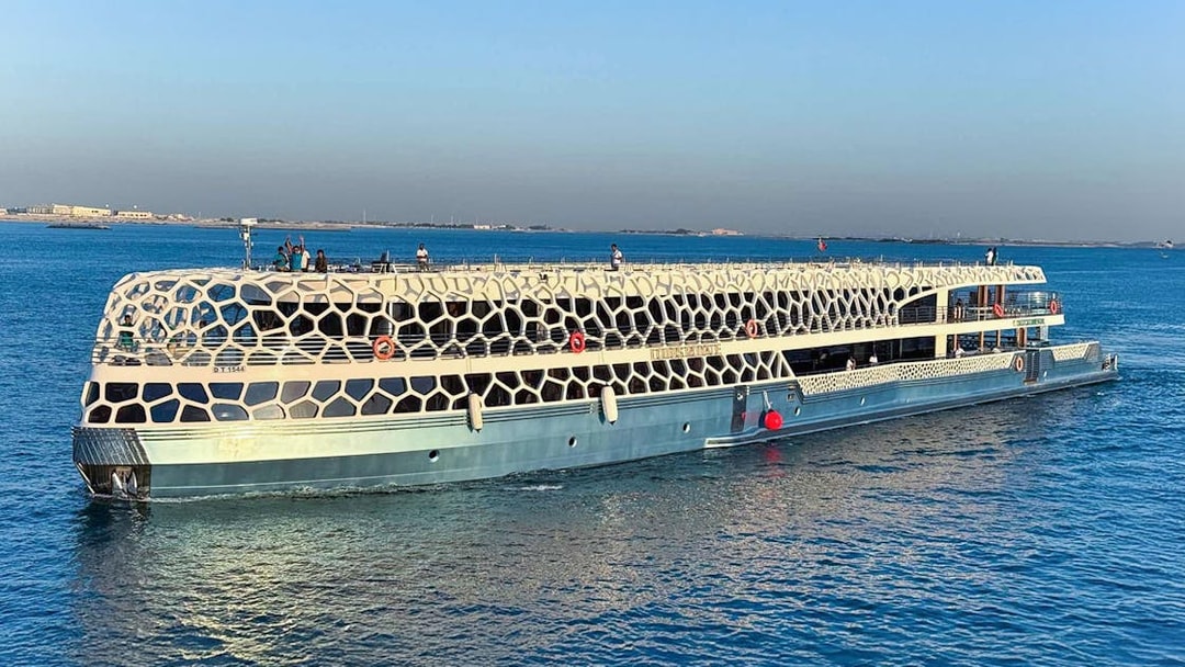 Lotus Mega Yacht cruising in Dubai Marina with guests on deck.