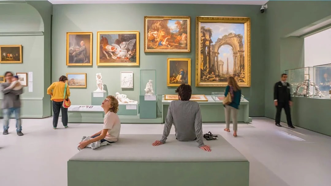 Tourists exploring art exhibits at the Louvre Museum Abu Dhabi.