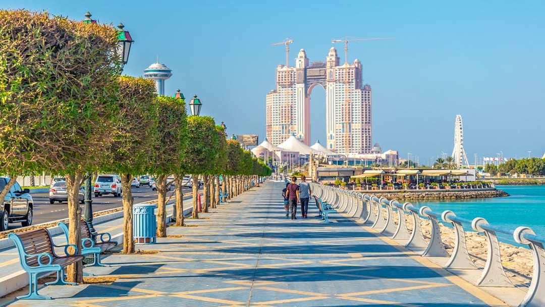 Abu Dhabi Corniche with skyscrapers and waterfront promenade, part of full-day sightseeing tour.