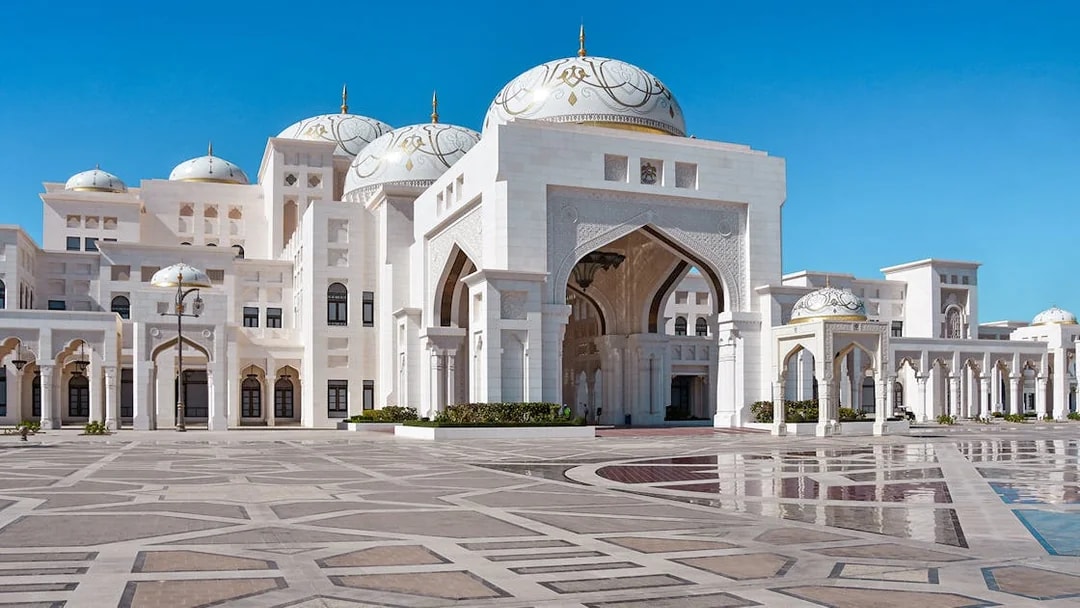 Abu Dhabi's Qasr Al Watan palace with intricate domes and arches on a clear day.