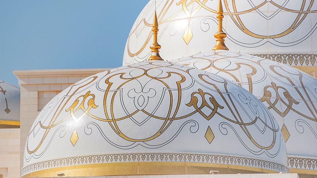 Ornate domes of Qasr Al Watan in Abu Dhabi with intricate gold patterns.