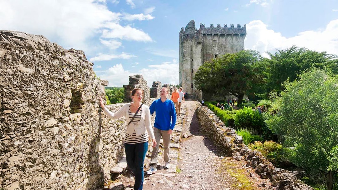 Tourists walking along the stone path at Blarney Castle, Ireland.