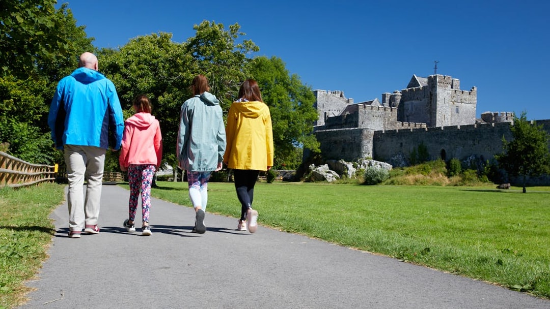 Group walking towards historic castle on a sunny day.