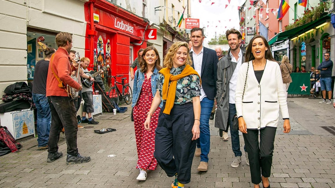 Tour guide leading a group through a lively street with musicians performing.