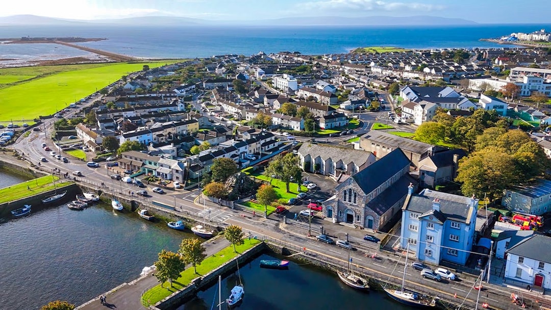 Aerial view of Galway city, Ireland, featuring coastal buildings and boats along the waterfront.