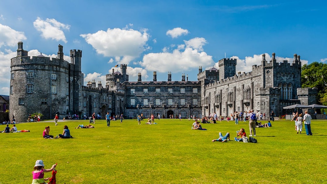 Visitors enjoying the gardens in front of Kilkenny Castle, Ireland.