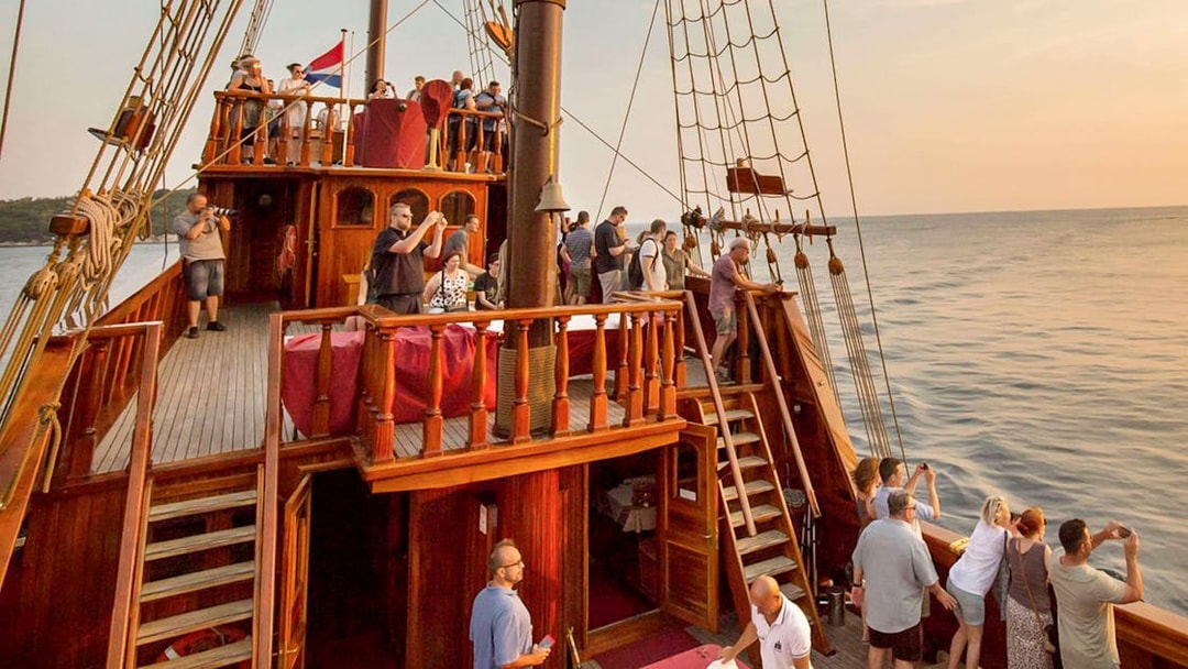 Guests on Karaka Ship enjoying sunset views during a cruise.