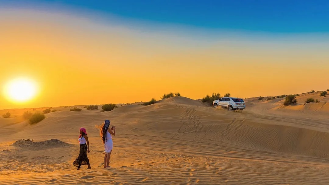Desert safari with dune bashing and sandboarding in Dubai at sunset.