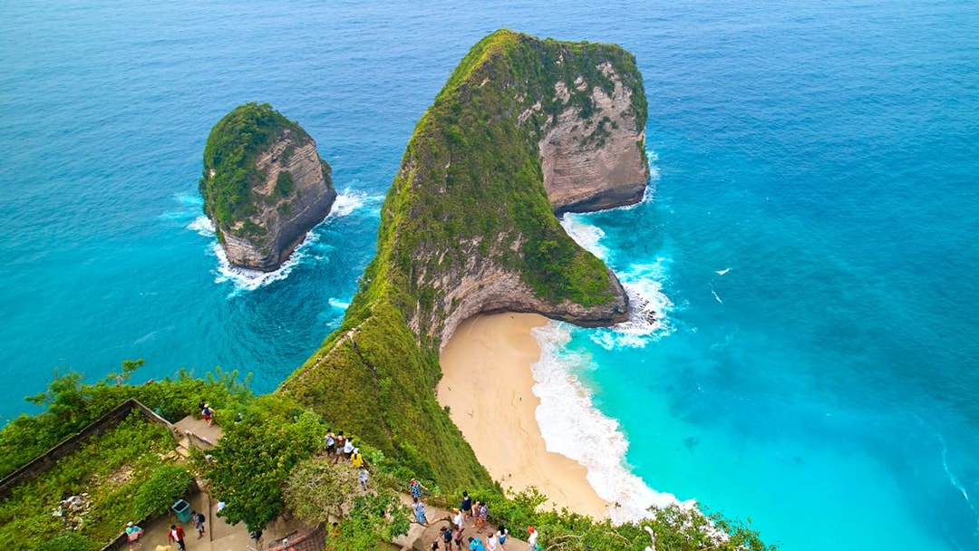 Tourists enjoying the view of Kelingking Beach, West Nusa Penida Island, Indonesia.