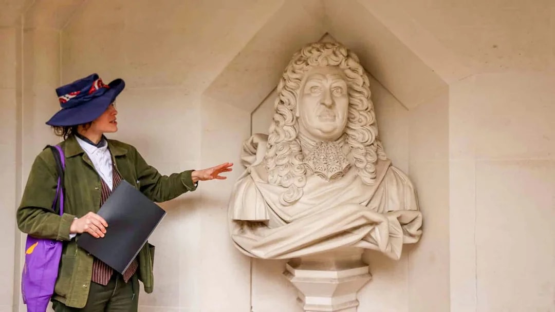 Tour guide explaining a historical statue in London during the Heart of 'The City' Food Tour.