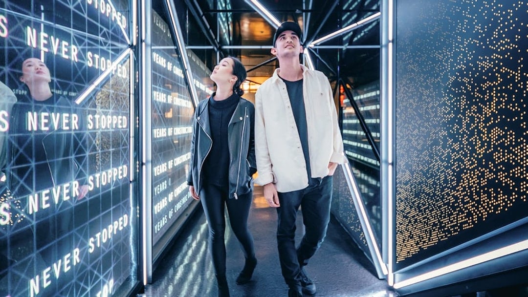 Visitors walking through a futuristic corridor at Edge, New York City.