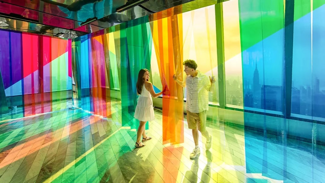 Couple exploring colorful installation at Edge Observation Deck, New York City.
