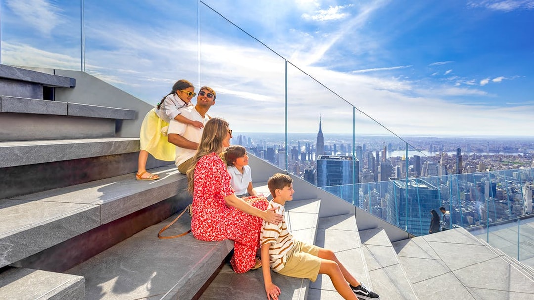 Family enjoying view from Edge Observation Deck, New York City, with skyline and Empire State Building.