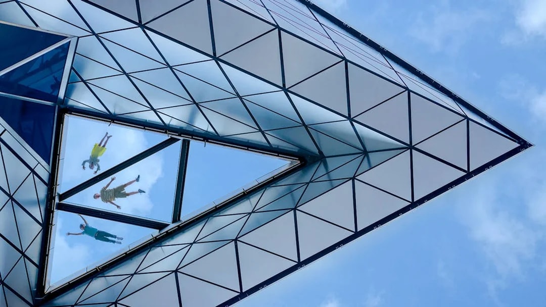 View of people walking on the glass floor at Edge, New York City, from below.