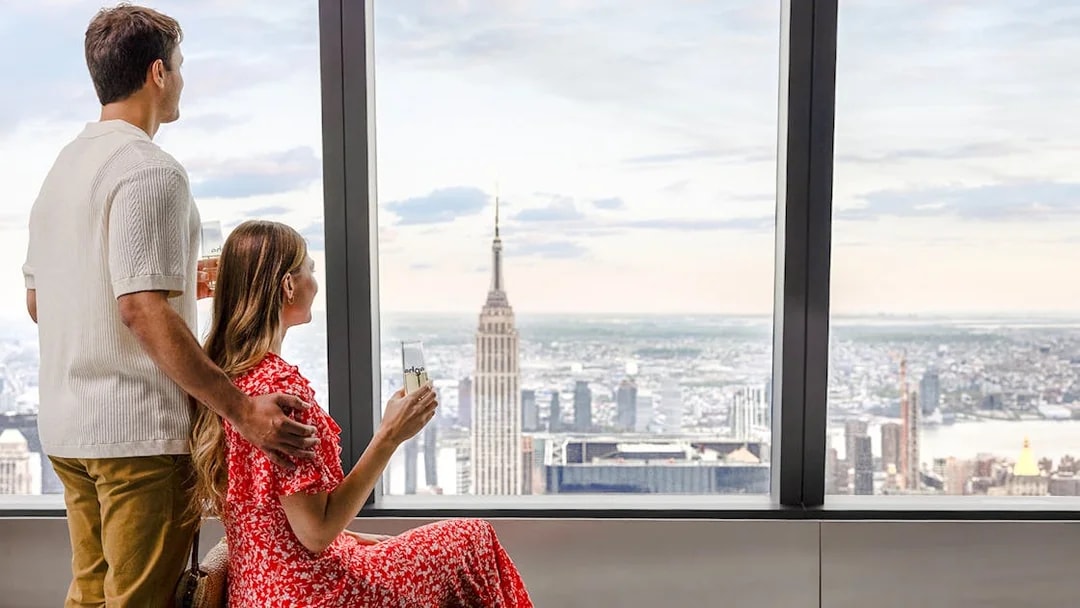 Couple enjoying the view of the Empire State Building from the Edge indoor sky deck.