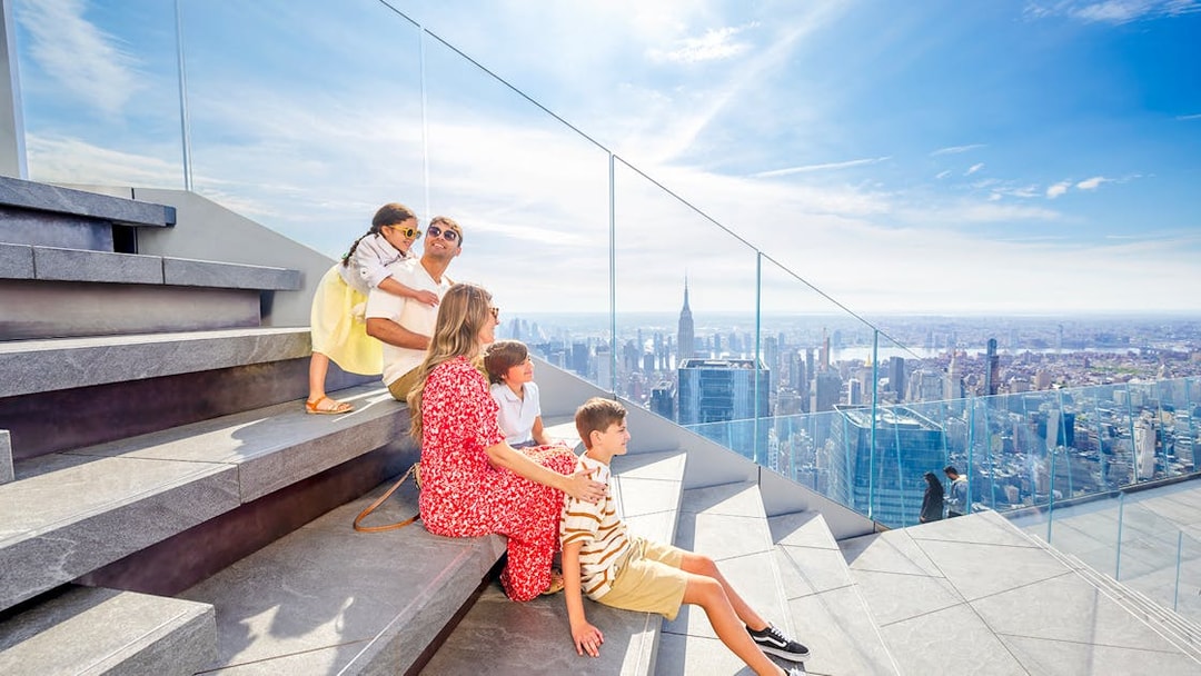 Family enjoying skyline view from Edge observation deck in New York City.