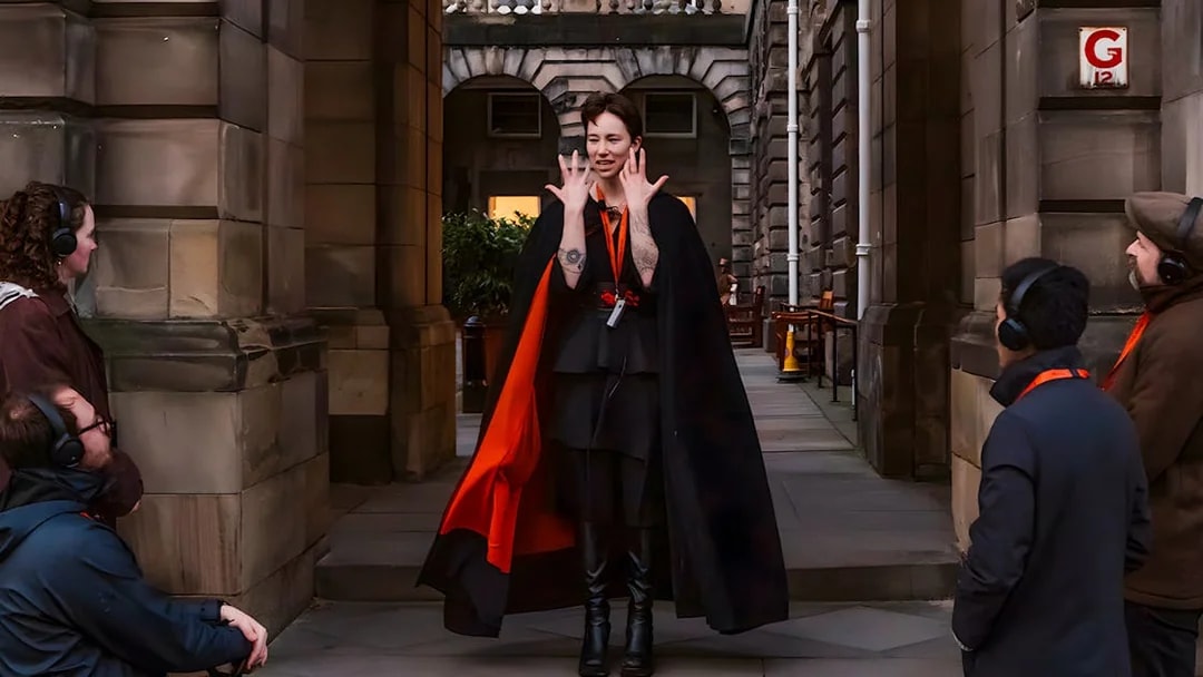Guide leading Edinburgh Royal Mile ghost tour with guests using audio guides.