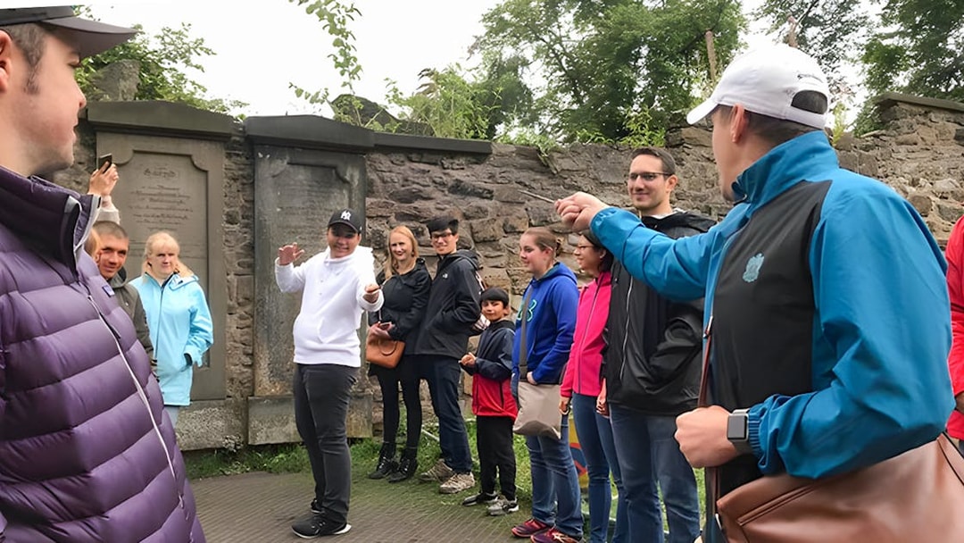 Group on Harry Potter walking tour with guide demonstrating wand technique.