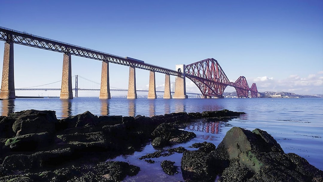 Forth Bridge over water near Edinburgh, part of Whisky & Waterfalls Day Tour.