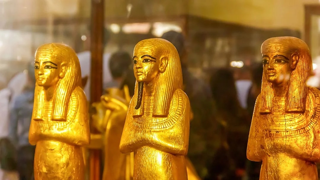 Golden statues of ancient Egyptian figures at the Egyptian Museum of Antiquities.