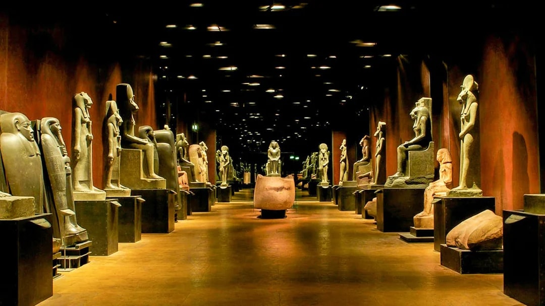 Ancient statues in a dimly lit hall at the Egyptian Museum, Cairo.