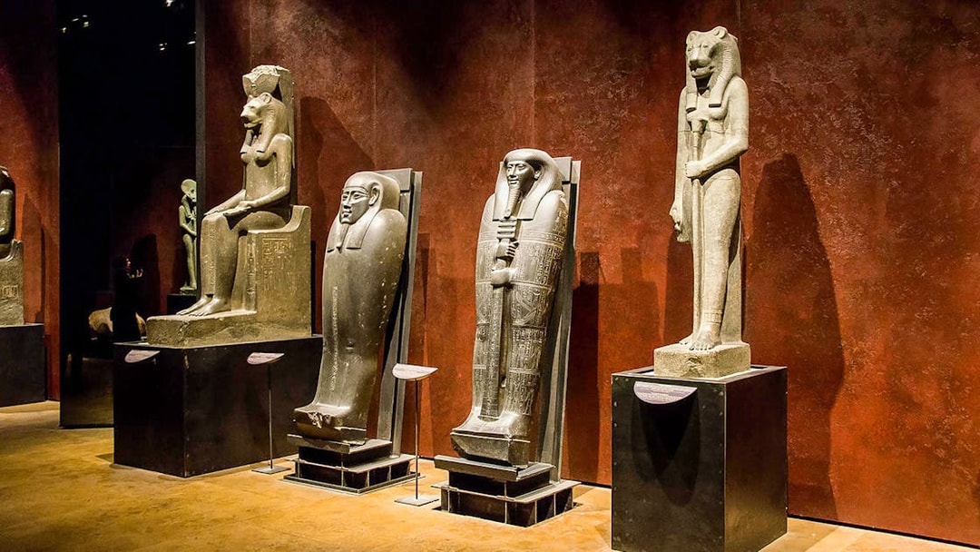 Ancient Egyptian statues and sarcophagi displayed in the Egyptian Museum.