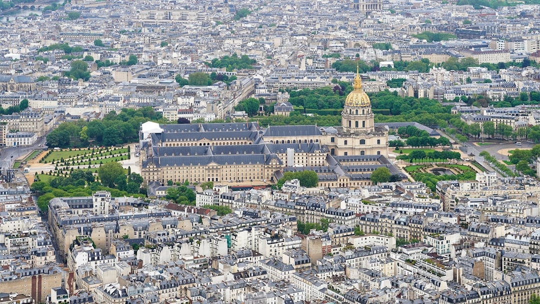 Aerial view of Paris from the Eiffel Tower, featuring Les Invalides and surrounding cityscape.