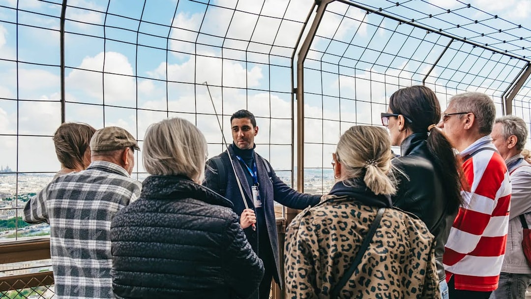 Tour guide explaining to a group on the Eiffel Tower's viewing platform, Paris.